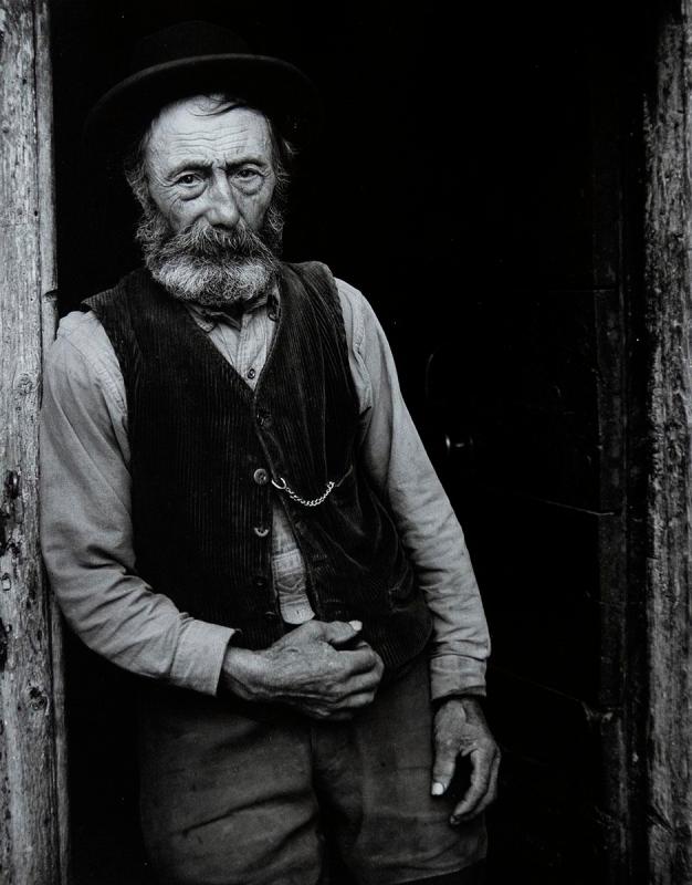 Man in vest with hat standing in doorway, Savoie